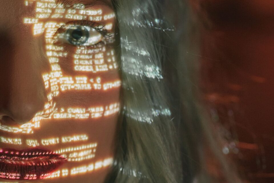 Digital code projected across a face for synthetic media and deepfake research